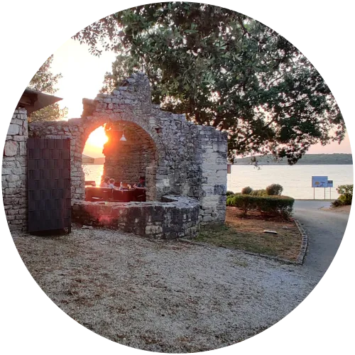 Sonnenuntergang im Restaurant San Pol am Campingplatz Mon Perin, eingebettet in die historischen Ruinen der alten Kirche mit Blick auf das Meer