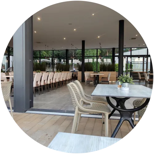 Modernes Restaurant mit Außenterrasse am Camping Omišalj Ein Blick auf den modern eingerichteten, hellen Innenbereich und die Außenterrasse des Restaurants auf dem Campingplatz Omišalj mit gedeckten Tischen und bequemen Stühlen.